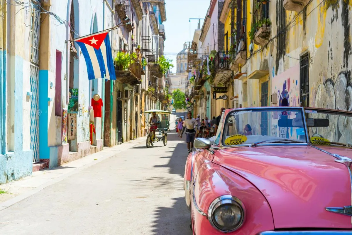 Calle con un coche en una ciudad de cuba